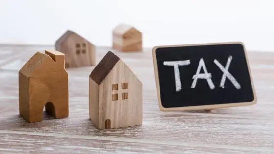 Image showing model wooden houses with a blackboard with the words Tax written on it depicting LBTT